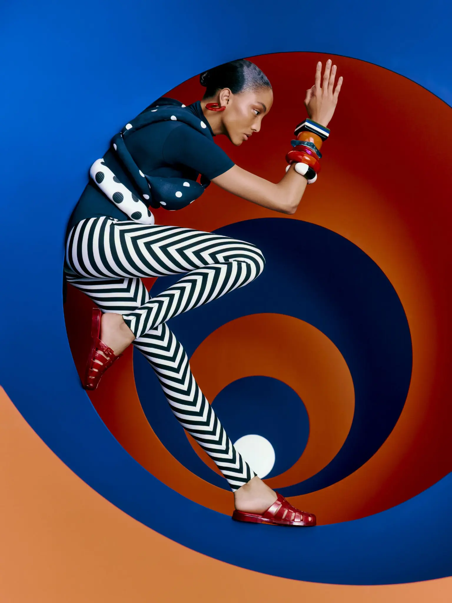 Campaña de Melissa con sandalias rojas y una composición gráfica azul y naranja.
